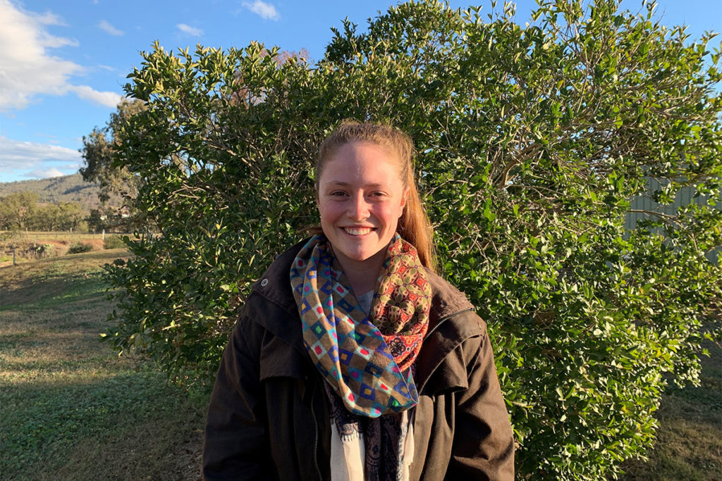 Mikaela standing in front of a tree